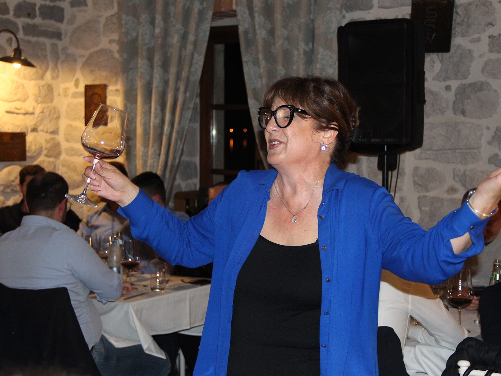 Guest of Conte restaurant singing while holding a glass of wine